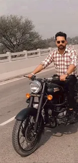 Man riding a classic motorcycle on a scenic road.