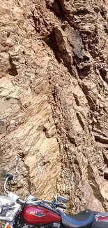 Motorcycle parked in front of rugged rock formation, exuding adventure.