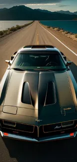 Classic muscle car on scenic mountain road with lake view wallpaper.