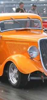 Vibrant orange vintage car on a race track creating dynamic motion.