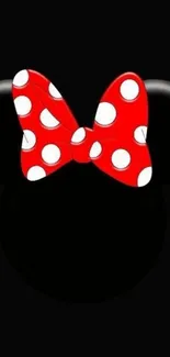 Mobile wallpaper with red polka dot bow on black background.