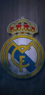 Real Madrid emblem on wooden background.