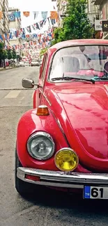 Red Volkswagen Beetle parked on a lively city street with flags above.