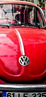 Red vintage Volkswagen Beetle parked in an urban setting with classic design elements.