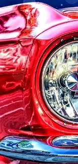 Close-up of a vibrant classic red car with detailed headlight.