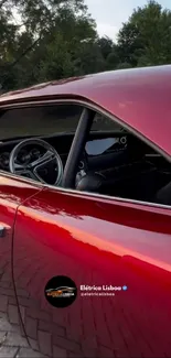 Red classic car with lush green scenery