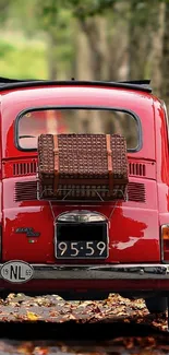 Classic red Fiat parked on a leafy roadside, perfect for vintage car enthusiasts.