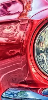 Close-up of a shiny red classic car with detailed reflections.