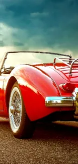 Red vintage convertible car at sunset on open road.