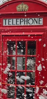 Red telephone booth in wintery setting with snow.