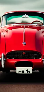 Classic red vintage roadster on a scenic highway.