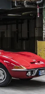 Vintage red sports car in an industrial setting mobile wallpaper.