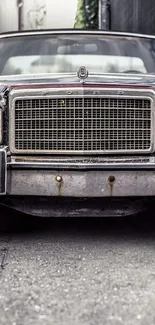 Front view of a vintage Ford car with detailed grille in an alley.