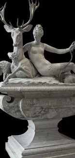 Classical marble sculpture with a woman, stag, and lamb on a dark background.