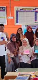 Group photo of students and teachers in a colorful classroom setting.