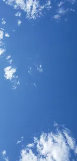 Clear blue sky with scattered white clouds wallpaper.