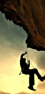 Silhouette of climber at dusk on rock wall with dramatic sky.