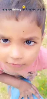 Close-up portrait of a child with an expressive face outdoors.