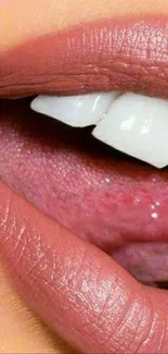 Close-up view of lips with pink lipstick and white teeth.