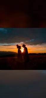 Silhouetted couple against a vibrant sunset.