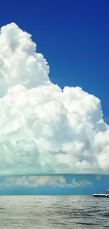 Mobile wallpaper with ocean and towering clouds.