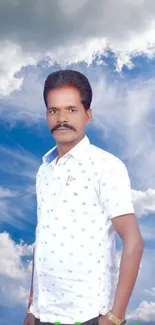 Portrait of a person against a cloudy blue sky background.