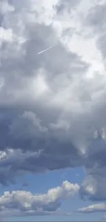 A serene cloudy sky with an airplane streak.