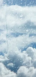 Raindrops on glass with cloudy sky background.