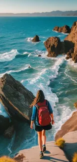 Hiker walking on rocky coastline with ocean view.