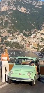 Vintage car on coastal road with mountain view.