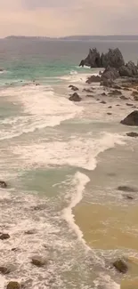 Serene coastal beach with rocky shore and gentle waves.