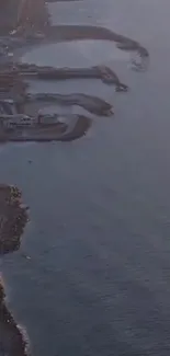 Aerial view of a coastal sunset scene with ocean and shoreline.