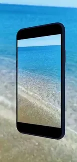 Mobile phone with a beach view on screen, featuring blue ocean.