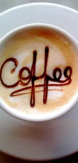 Coffee cup with artistic chocolate writing on a marble table.