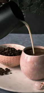 Coffee being poured into a pink ceramic mug with beans on a table.