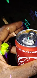 Hand holding a Coke can and lighter with cigarette.