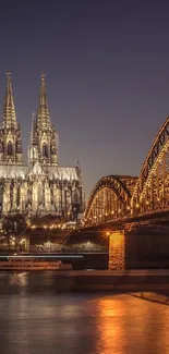 Night view of Cologne Cathedral and Hohenzollern Bridge by the Rhine.