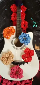 White acoustic guitar with colorful fabric flowers and musical notes.