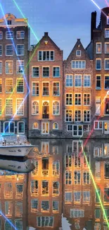 Amsterdam canal at night with colorful lights and reflections on buildings.