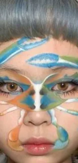 Face with colorful blue, green, and orange artistic paint.