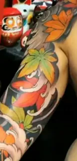 Vibrant tattoo design with colorful leaves on an arm in a mobile wallpaper.