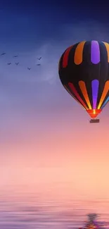 Colorful hot air balloon in serene sky over water.