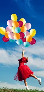 Person in red dress flying with colorful balloons against a blue sky.