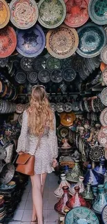 Woman in vibrant bazaar surrounded by colorful pottery.