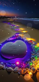 Colorful heart-shaped beach art with glowing stones at night.