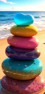 A vibrant stack of colorful stones on a sunlit beach beside the ocean.