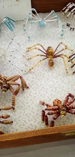 Artistic beaded spiders showcased on a patterned fabric display.