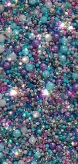 Vibrant glittering beads in teal, purple, and pink create a colorful background.