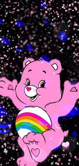 Cheerful pink bear with rainbow on black starry backdrop wallpaper.