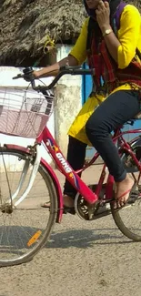 Woman bicycling on street in colorful attire.